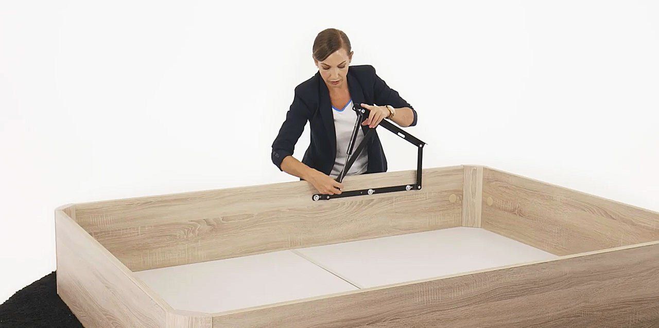 mujer montando canapé abatible de madera