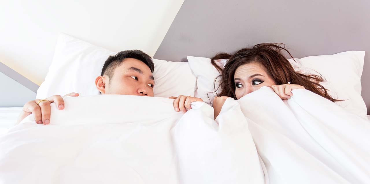 pareja mirándose en las sábanas pareja mirándose en las sábanas