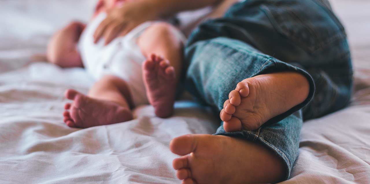 pies de niño y de bebé en colchón