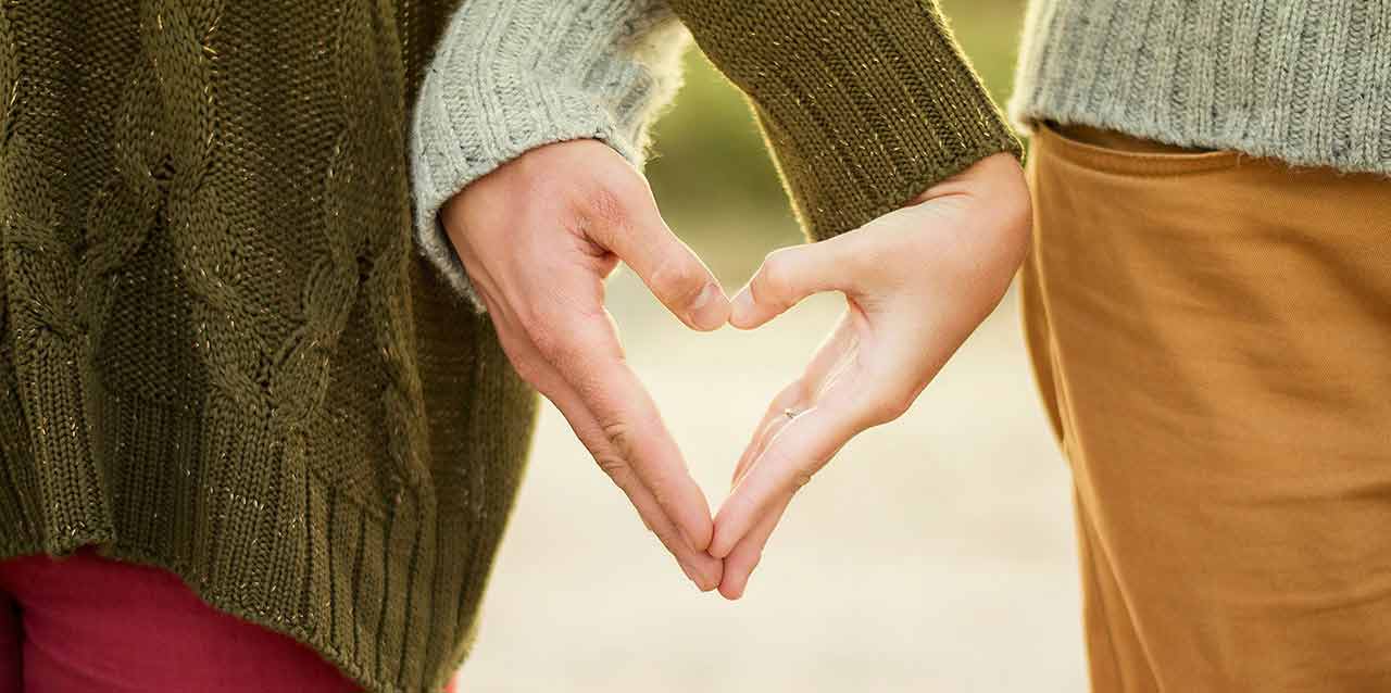 pareja dibujando corazón con las manos