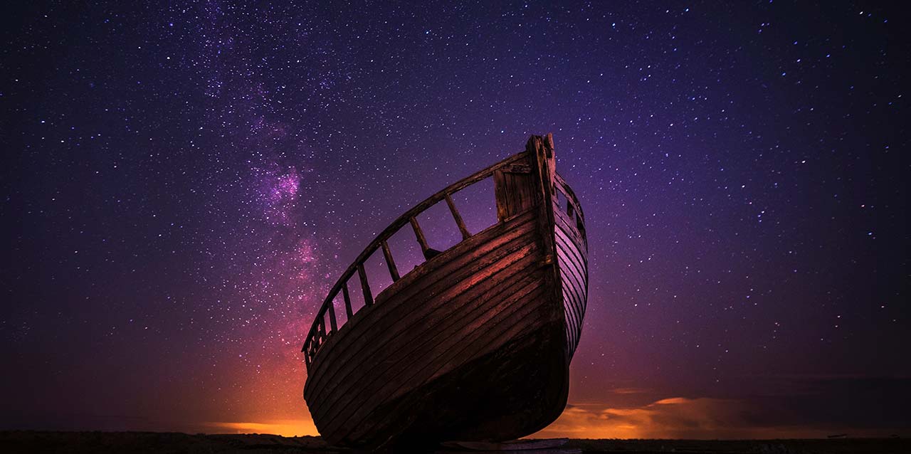 barco navegando en la noche con cielo estrellado