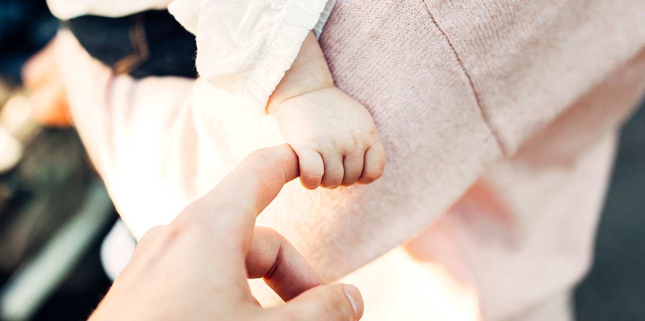 mano de bebé cogiendo dedo de persona