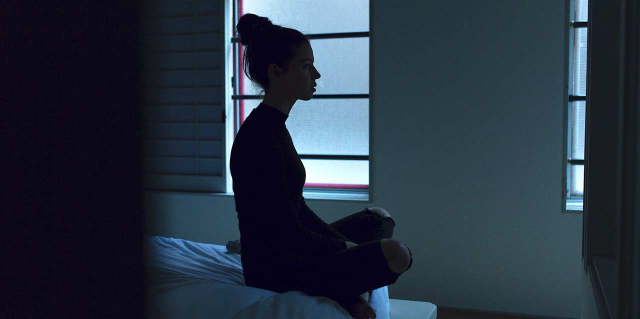 mujer con insomnio sentada en borde de cama mujer con insomnio sentada en borde de cama