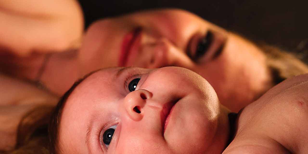 bebé mirando hacia arriba tumbado con madre