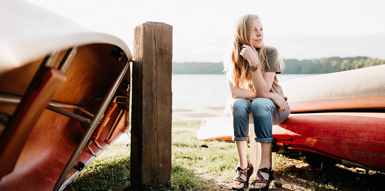 chica sentada junto a kayak