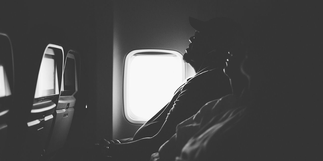 pasajeros durmiendo en avión en blanco y negro