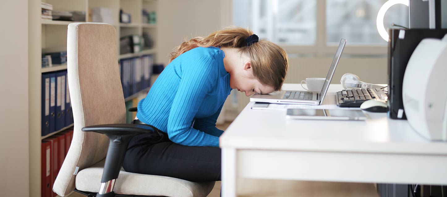 estudiante con deficiencia de sueño durmiendo en su escritorio con la cabeza apoyada en su ordenador portatil