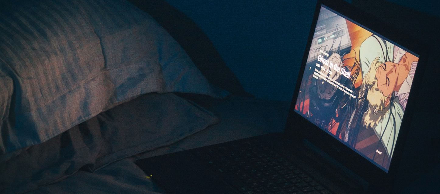 laptop apoyado sobre la cama con una serie