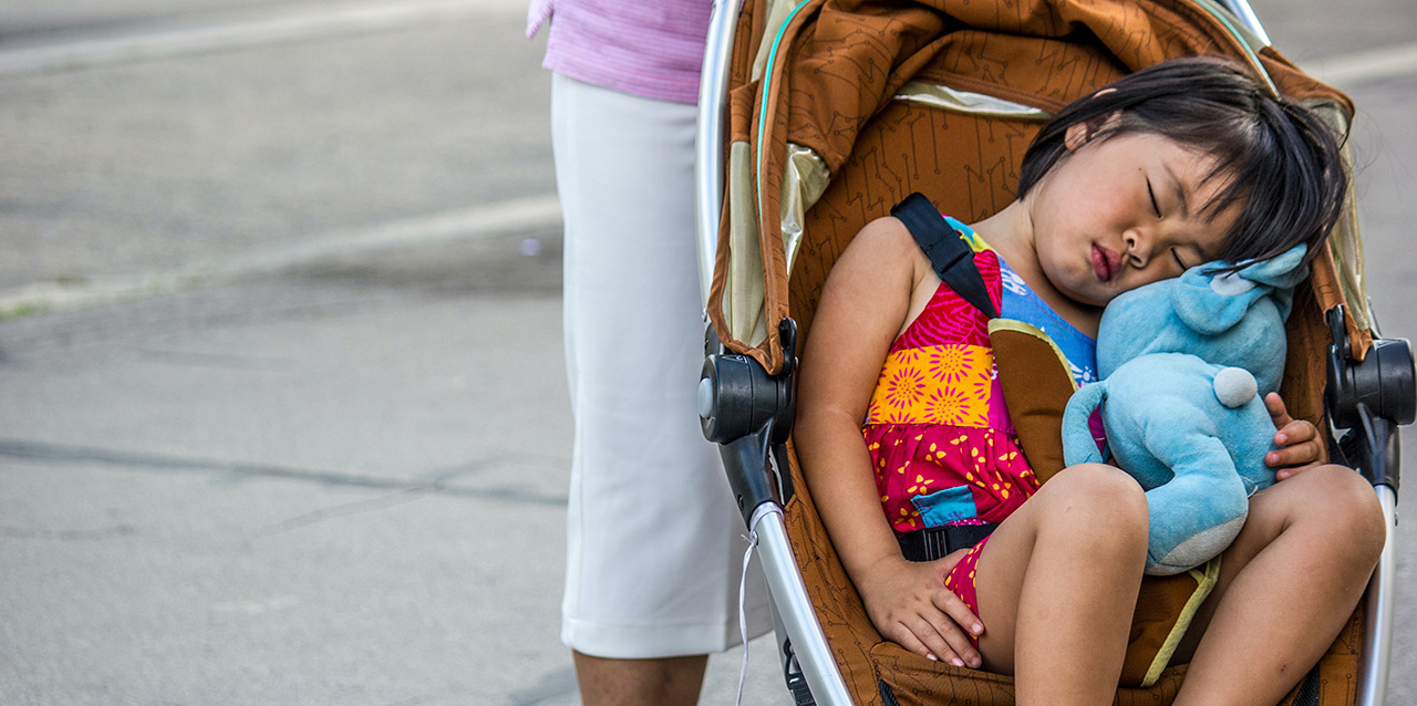 menina a dormir no carrinho de bebé